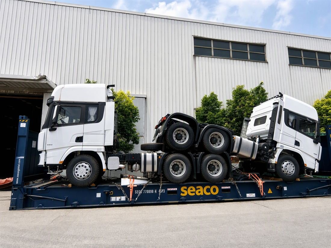 Trucks and trailers secured inside and onto containers for shipment from a Chinese port