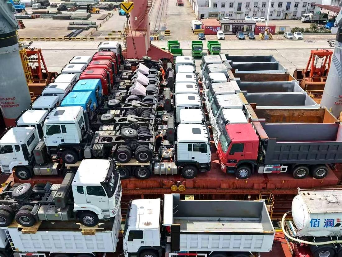 Trucks and trailers lashed and blocked with timber dunnage for shipment from a Chinese port